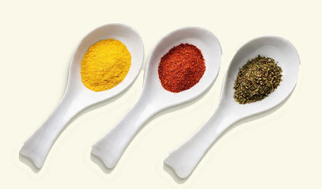 Three spoons with visibly smaller portions of turmeric, chilli and herbs, representing typical usage with 3S spices